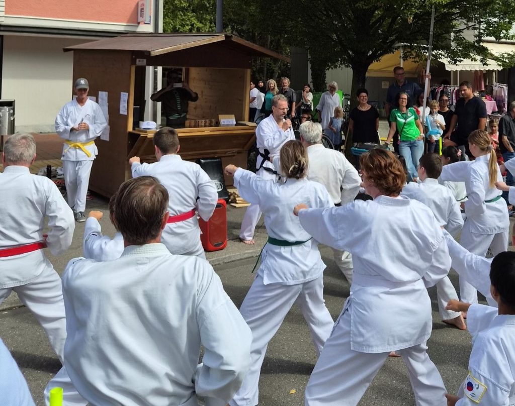 team der Schule auf dem STraßenfest beim Fauststoß, Ralph gibt das Kommando